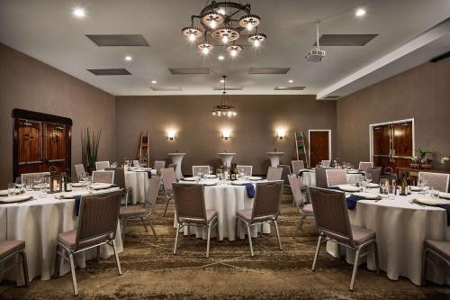 a banquet room with white tables and chairs and a chandelier at Hilton Tapestry Collection, Hotel Don Fernando De Taos in Taos