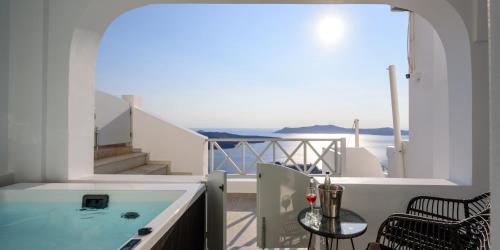 a balcony with a hot tub and a view of the ocean at Elia Caldera Suites in Fira