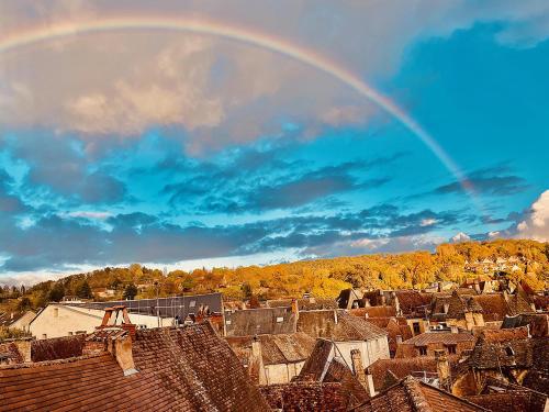 a rainbow in the sky over a city at Appartement la Belle Vue Panoramique in Sarlat-la-Canéda