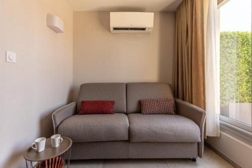 a couch in a living room with a window at At home in Clermont, Place de Jaude in Clermont-Ferrand