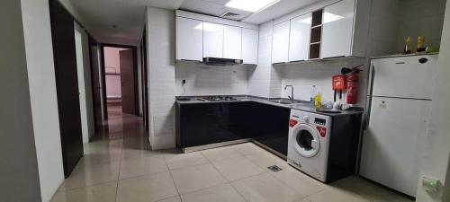 a kitchen with a washing machine and a washer at DraGon Executive Homes 002 in Dubai