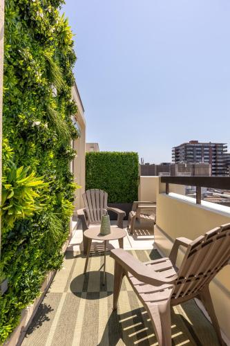a rooftop patio with chairs and a green wall at At home in Clermont, Place de Jaude in Clermont-Ferrand
