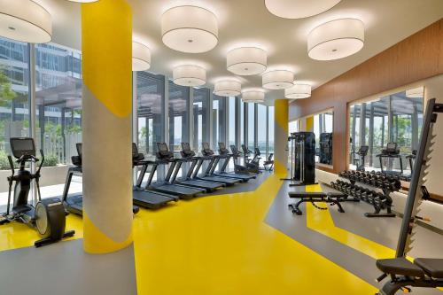 a gym with a row of treadmills and machines at Embassy Suites By Hilton Dubai Business Bay in Dubai
