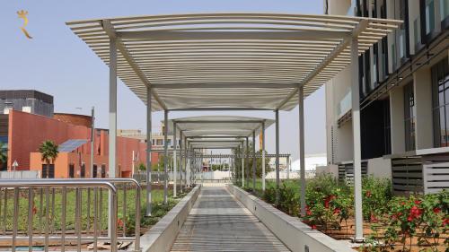 a canopy over a walkway in a city at Plush 2BR Retreat in Masdar City - Modern Stay Near Masdar Park & City Centre in Abu Dhabi