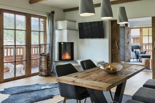 a living room with a wooden table and a fireplace at Das Chalet in Schladming
