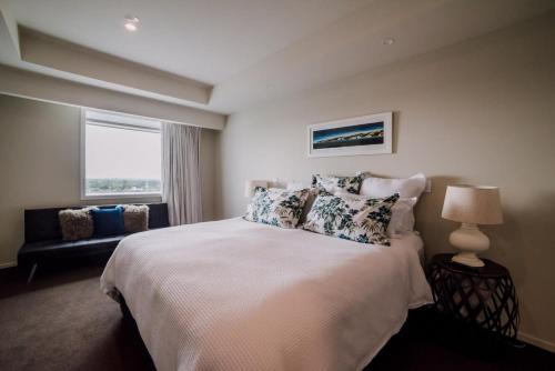 a bedroom with a large bed and a window at Sleep Amongst the Clouds - Panoramic Views in Christchurch