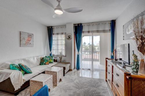 a living room with a couch and a tv at Loro Apt Playa de las Americas in Playa Fañabe