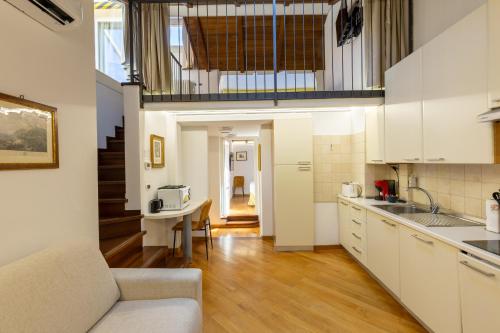a kitchen with white cabinets and a table in a room at BolognaRoomscom - Frassinago Deluxe in Bologna