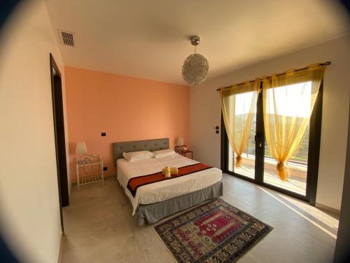 une chambre avec un lit et une grande fenêtre dans l'établissement Belletoile, à Montauroux