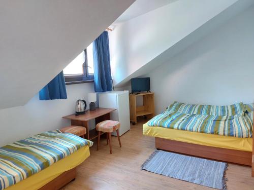 a room with two beds and a desk and a table at Baltic in Łeba