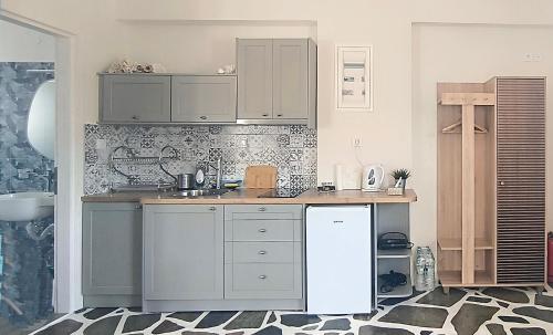 een keuken met witte kasten en een witte koelkast bij Dendrinos studio in Galissas
