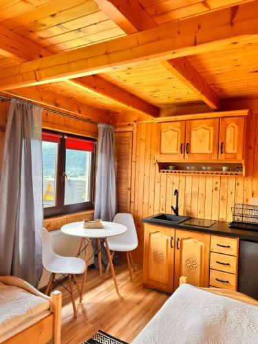 une cuisine avec une table et des chaises dans une cabine dans l'établissement Z widokiem na Giewont, à Kościelisko