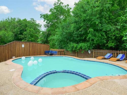 a swimming pool in a yard with chairs and a fence at Captivating 6BR 3BA Holiday Home with Pool & Fire Pit in Mesquite