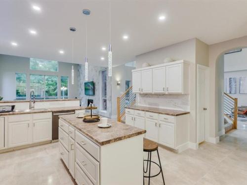 a large kitchen with white cabinets and a large island at Captivating 6BR 3BA Holiday Home with Pool & Fire Pit in Mesquite