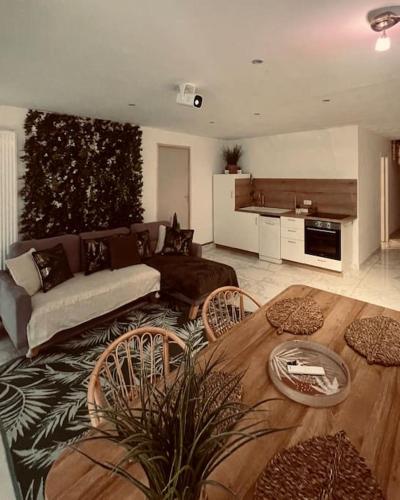 un salon avec un canapé et une table dans l'établissement Jungle Suite, Jacuzzi à 7 min de la mer, à Calais