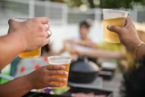 two people holding up two glasses of beer at 遊びの宿 海陽 in Wakugawa