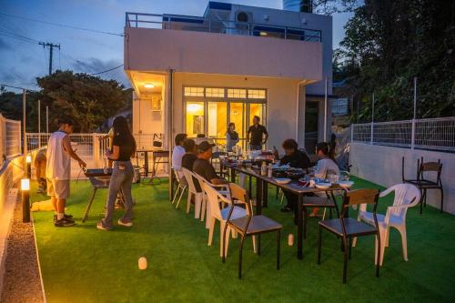 a group of people sitting at tables on a patio at 遊びの宿 海陽 in Wakugawa