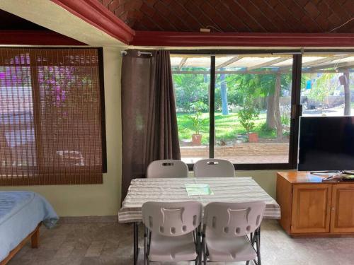 a room with a table and chairs and a bedroom at Bungalow And Surf in Cabo San Lucas