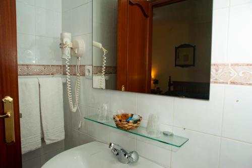 a bathroom with a sink and a phone on the wall at Posada Peñas Arriba in Lon