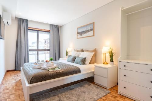 a bedroom with a bed and a window at Host Wise - Bright and Elegant Urban Flat with Balcony in Porto