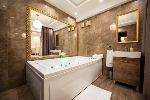 a bathroom with a large tub and a mirror at Central Business Apartments Jacuzzi in Belgrade