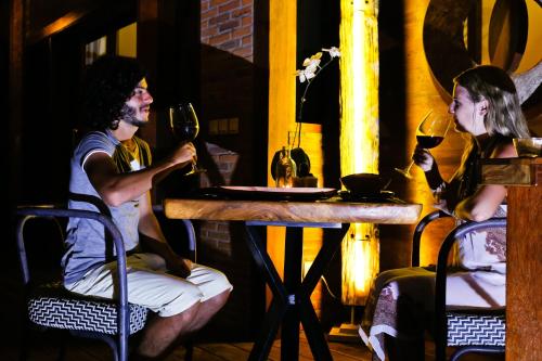 a man and woman sitting at a table with wine glasses at Kaleydo Villas in Gili Trawangan
