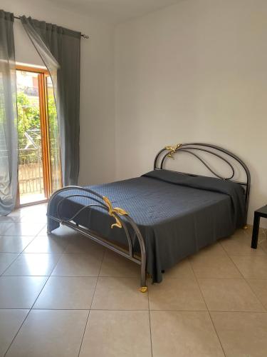 a bed sitting in a room with a window at Il Pino Argentato in Gragnano