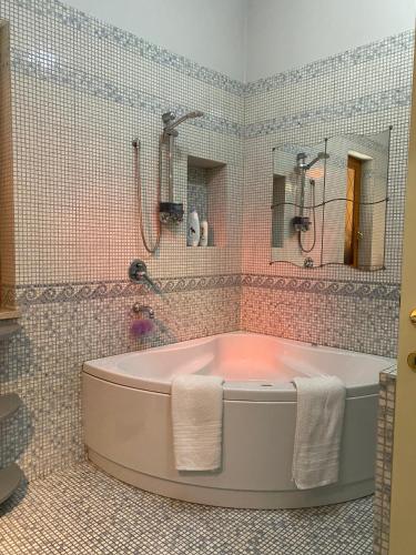 a bathroom with a tub and a tiled wall at Il Pino Argentato in Gragnano