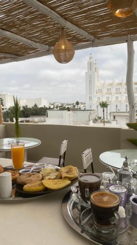 a table with a plate of food and coffee on it at TheCasaEdition Gauthier Residency City Center in Casablanca