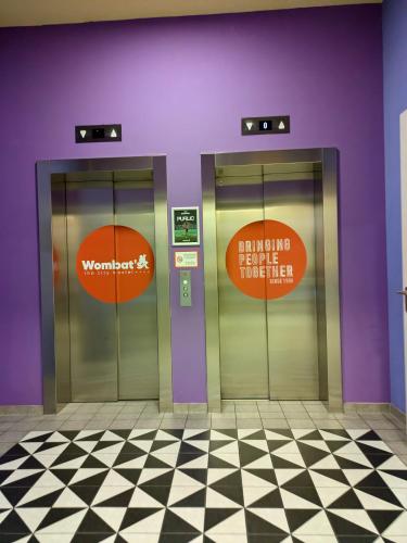 two elevators in a building with signs on them at Wombat's City Hostel Munich Werksviertel in Munich