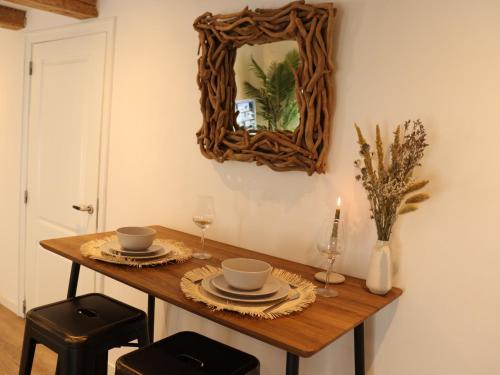 a table with a mirror on a wall with a table with glasses at Coolest Apartments in Haarlem City - close to Beach and Amsterdam in Haarlem