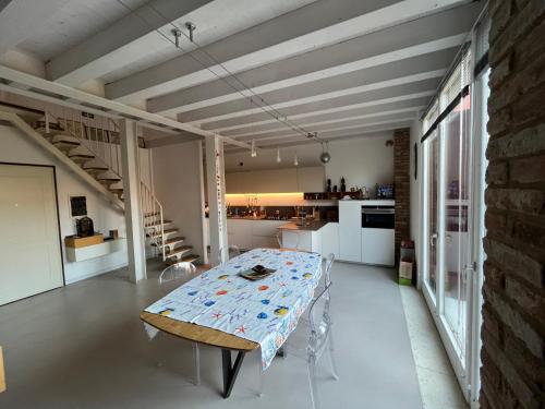 a dining room with a table and a kitchen at Le Vele Del Cigno in Peschiera del Garda
