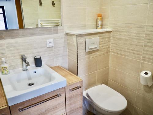 une salle de bain avec un lavabo blanc et des toilettes dans l'établissement Auberge du Cronquelet, à Saint-Aubin
