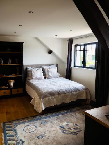 une chambre avec un lit et une fenêtre dans l'établissement Auberge du Cronquelet, à Saint-Aubin