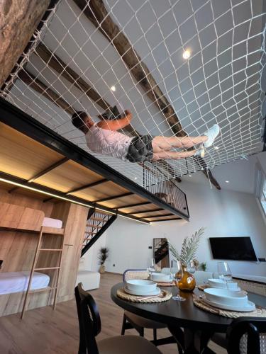 a man is lying on a suspended bed in a room at Ferrol by Miramar Stays in Ferrol