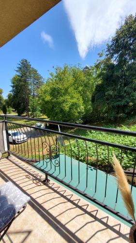 a balcony with a bench and a view of a park at Apartman LiBra in Banja Koviljača