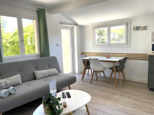 un salon avec un canapé et une table dans l'établissement L'Auguière Est, maisonnette sans vis-à-vis et au calme avec vue sur les vignes, à Hyères