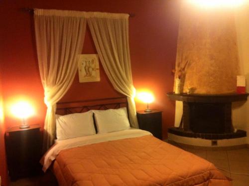 a bedroom with a bed and a fireplace with two lamps at Eu Zin in Vytina