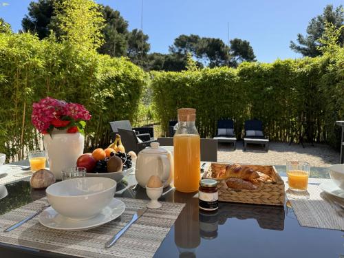 une table avec un petit-déjeuner composé de pain et de jus d'orange dans l'établissement L'Auguière Est, maisonnette sans vis-à-vis et au calme avec vue sur les vignes, à Hyères