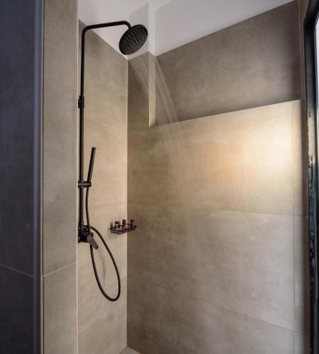a shower with a shower head in a bathroom at Elia Caldera Suites in Fira