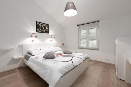 1 dormitorio blanco con 1 cama grande con sábanas blancas en Kuca za odmor Diraki R, en Rijeka