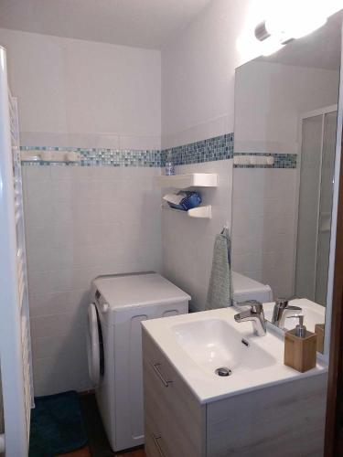 une salle de bain blanche avec un lavabo et des toilettes dans l'établissement Appartement chalet en plein centre des Saisies, à Hauteluce