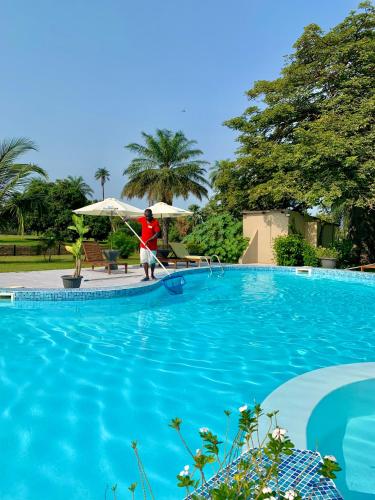 a man is paddling a paddle in a swimming pool at Kololi Beach Resort in Kololi