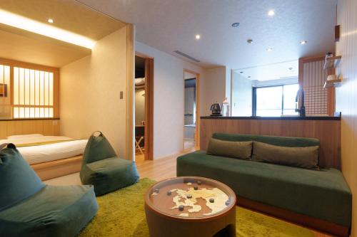 a living room with a couch and a bed at UreshinoOnsen URESHINO YADOYA in Ureshino