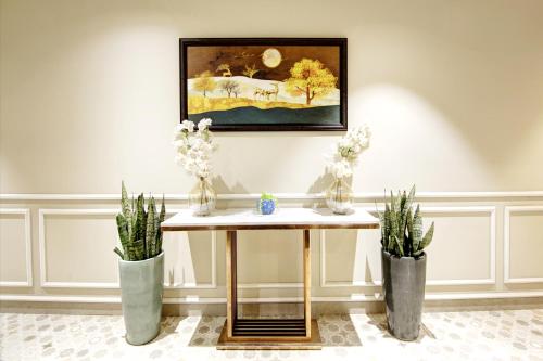 a table in a room with two potted plants at Saltstayz Premier - Cyber Hub in Gurgaon
