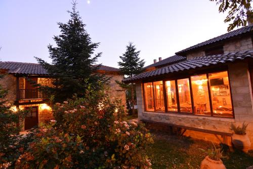 una casa con muchas ventanas en un patio en Helydorea zen en Synikia Mesi Trikalon