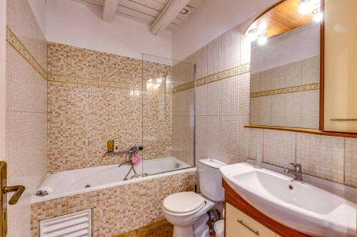 a bathroom with a tub and a toilet and a sink at Villa Epavlis by Villa Plus in Plaka