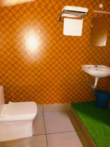 a bathroom with a toilet and a sink at Bamboo Suite at Merlys Fruit Garden in Kotamangalam