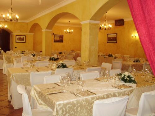 a banquet hall with white tables and white chairs at Tenuta Montelaura in Forino