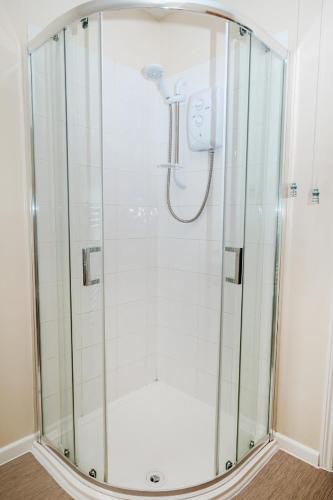 a shower with a clear glass enclosure in a bathroom at Above The Pub in Alvechurch